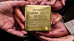 Verwandte halten den Stolperstein für Johanna Berger, die 1941 deportiert und ermordet wurde, vor deren früherem Wohnort in Berlin. 6. Mai 2026