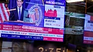 FILE. Screens display a news conference held by Federal Reserve chairman Kevin Warsh on the floor of the New York Stock Exchange, 16 Sept. 2026