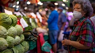 أرشيف - زبون يرتدي كمامة ينتظر شراء الخضروات في سوق "مارافيياس" في مدريد، الخميس 12 أيار 2022.