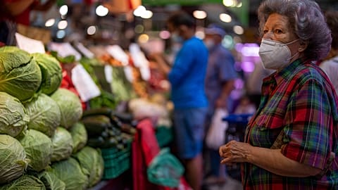 File - A customer wearing a face mask waits to buy vegetables at the Maravillas market in Madrid, Thursday, 12 May 2022.