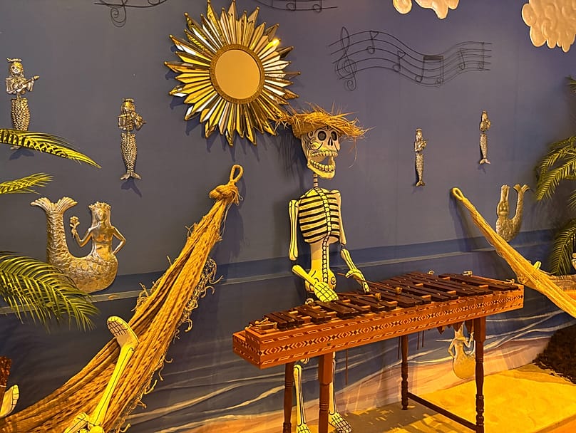 Imagen de una parte de la exposición por el Día de Muertos de 2026 de Casa de México con sirenas 'calavera' hechas de hojalata repujada..