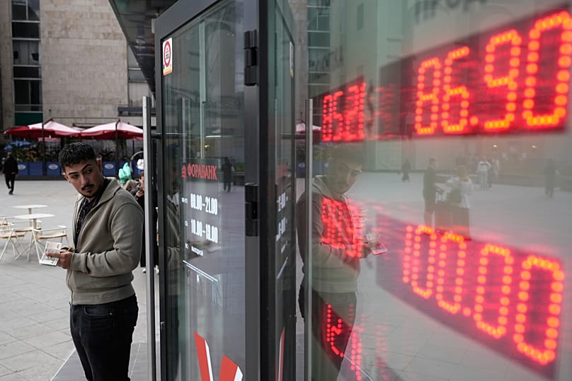 A man stands near an exchange office in Moscow, 14 August, 2026
