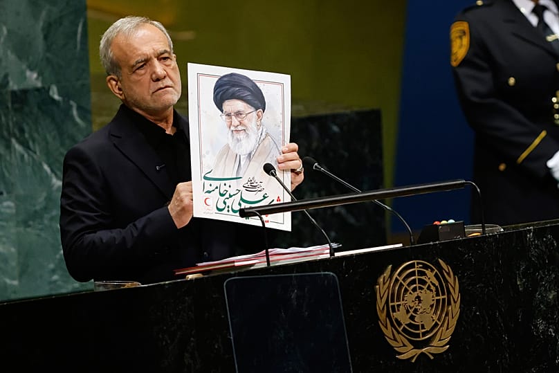 يرفع الرئيس الإيراني مسعود بزشكيان صورة للمرشد الأعلى الإيراني الراحل علي خامنئي في مقر الأمم المتحدة، يوم الأربعاء 23 سبتمبر 2026.
