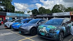 File - Handout photo provided by the Norwegian EV Association showing electric cars parked outside shops.
