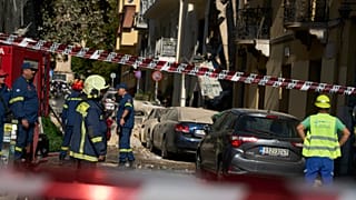Firefighters work at the scene following a powerful blast that caused a building to collapse and injured at least two people in Athens