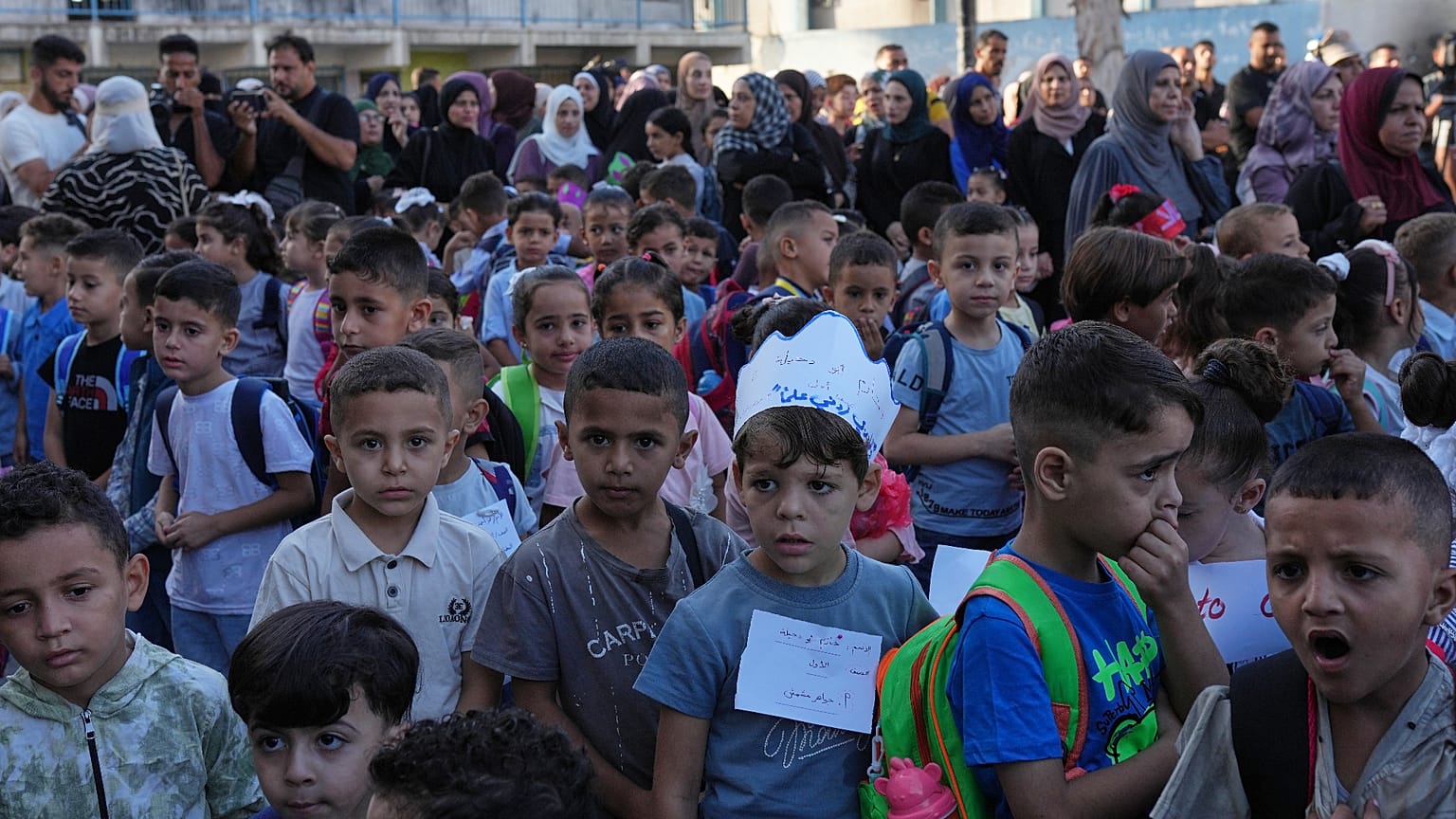 يصطف الأطفال الفلسطينيون في اليوم الأول من العام الدراسي الجديد في مدرسة تديرها الأمم المتحدة في النصيرات بوسط قطاع غزة