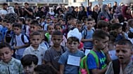 يصطف الأطفال الفلسطينيون في اليوم الأول من العام الدراسي الجديد في مدرسة تديرها الأمم المتحدة في النصيرات بوسط قطاع غزة
