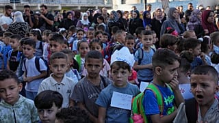 يصطف الأطفال الفلسطينيون في اليوم الأول من العام الدراسي الجديد في مدرسة تديرها الأمم المتحدة في النصيرات بوسط قطاع غزة