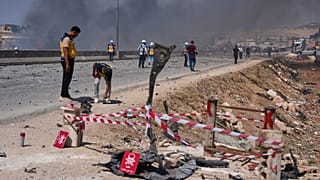 عناصر الدفاع المدني يتفقدون حطاماً وذخائر غير منفجرة إثر انفجار مستودع أسلحة قرب سرمدا بريف إدلب، في 9 سبتمبر 2026.
