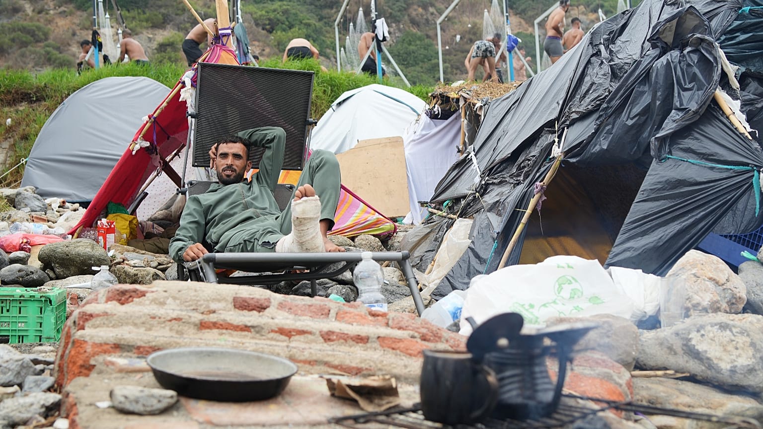 Un inmigrante está sentado junto a su tienda de campaña en la playa de El Trampolín, en el enclave español de Ceuta, el 2 de septiembre de 2026. 