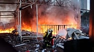 A rescue worker puts out a fire on the roof of an office building damaged by a Russian drone strike, in Kyiv, Ukraine, Friday, Sept. 25, 2026.