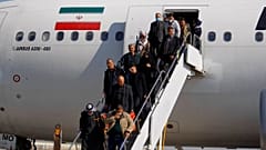 ركاب ينزلون من طائرة إيرانية في مطار النجف بالعراق، يوم الجمعة 21 فبراير 2020.