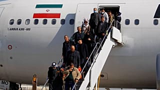 ركاب ينزلون من طائرة إيرانية في مطار النجف بالعراق، يوم الجمعة 21 فبراير 2020.