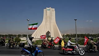 سائقو دراجات نارية يمرون بجوار برج نصب "آزادي" (الحرية) خلال مسيرة للدراجات النارية نظمتها الدولة تحت اسم "جانفادا" - وتعني "التضحية من أجل إيران" - في طهران، إيران