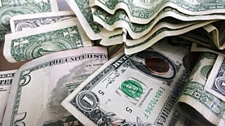 - تُظهر هذه الصورة الأرشيفية بتاريخ 6 سبتمبر 2017 جرة إكرامية تحتوي على أوراق نقدية بقيمة دولار واحد وخمسة دولارات