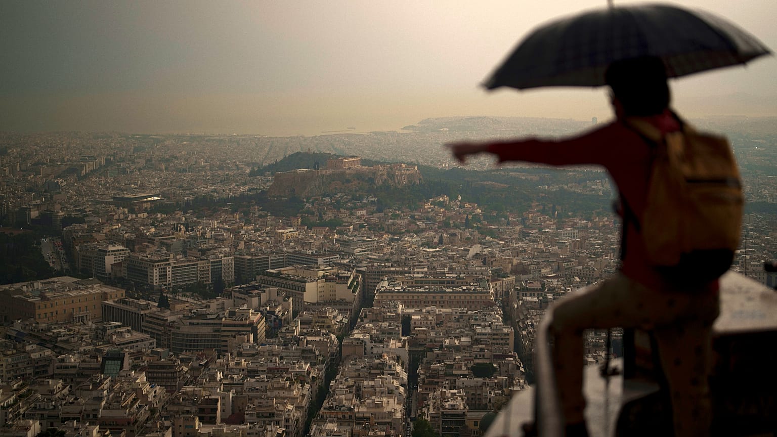 Τουρίστας με ομπρέλα στο Λυκαβηττό μετά από ξαφνική νεροποντή - φώτο αρχείου