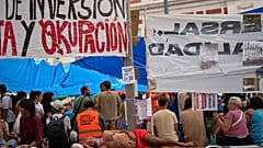 A man sleeps as protesters camp during a protest following the eviction last Wednesday of 87-year-old Maricarmen to demand stronger laws to protect renters.