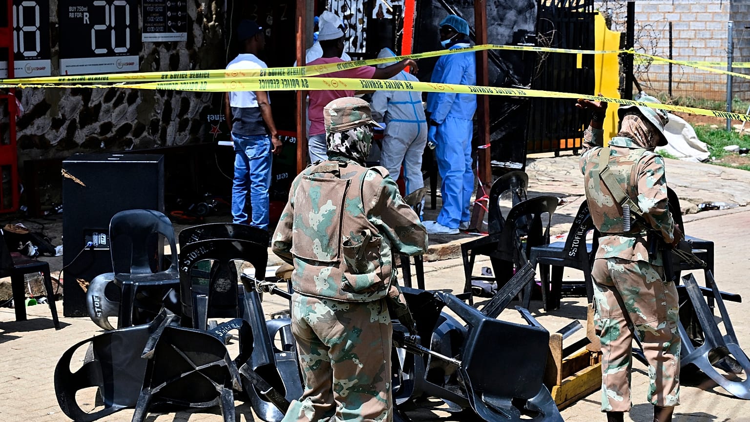 Des experts de la police scientifique et des militaires sur les lieux d'une fusillade de masse survenue samedi dans un bar de Wedela, en Afrique du Sud, le 27 septembre 2026