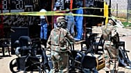 Des experts de la police scientifique et des militaires sur les lieux d'une fusillade de masse survenue samedi dans un bar de Wedela, en Afrique du Sud, le 27 septembre 2026