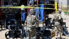 Des experts de la police scientifique et des militaires sur les lieux d'une fusillade de masse survenue samedi dans un bar de Wedela, en Afrique du Sud, le 27 septembre 2026