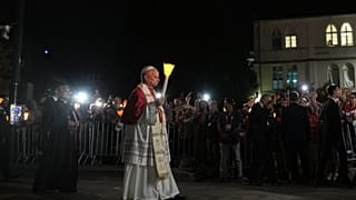 Papst Leo XIV hält während eines Rosenkranzgebets und einer Lichterprozession im Heiligtum Unserer Lieben Frau von Lourdes eine Kerze.