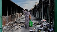 ARCHIVO - Una mujer observa libros carbonizados tras un incendio en el mayor mercado de libros de Ucrania provocado por un ataque ruso en agosto de 2026.