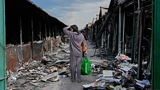 ARCHIVO - Una mujer observa libros carbonizados tras un incendio en el mayor mercado de libros de Ucrania provocado por un ataque ruso en agosto de 2026.