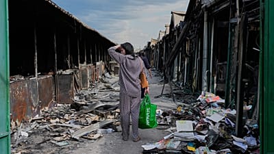 АРХИВ — Женщина смотрит на обугленные книги после пожара на крупнейшем книжном рынке Украины, вызванного российским ударом в августе 2026 года.