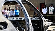 Community members stand at scene of a mass shooting at a bar in Wedela township, 27 September, 2026