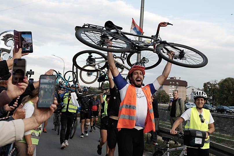 People welcome a group of university students at the end of their cycling tour of Serbia ahead of a snap election next month, 26 September, 2026