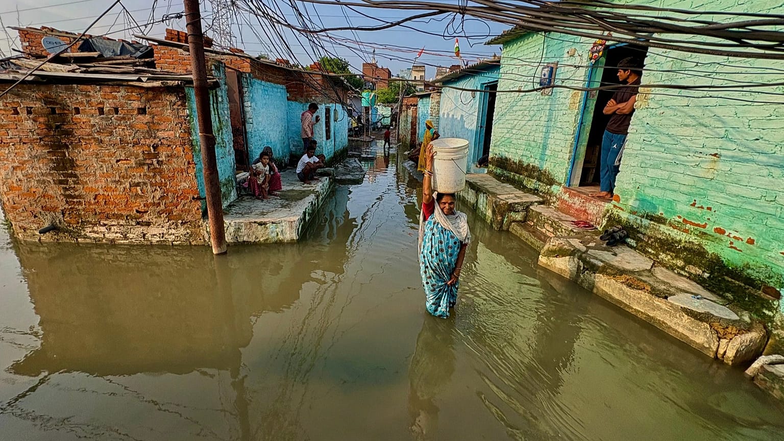 A woman wades through floodwaters in her neighbourhood following heavy rains in Kanpur, 22 September, 2026