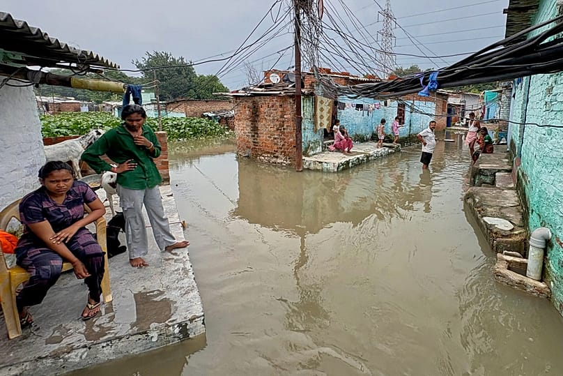 Residents of a low-lying neighbourhood watch as floodwaters submerge their area following heavy rains in Kanpur, 22 September, 2026