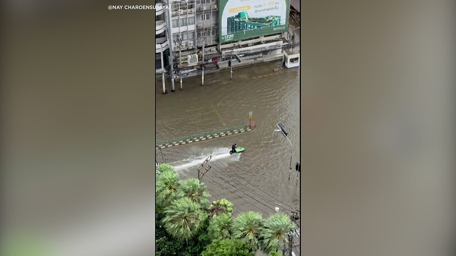 Un motorista de moto acuática recorre las calles inundadas de Bangkok