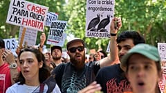 Архив: люди держат плакат с надписью на испанском «Дома для тех, кто в них живёт» на акции протеста в Мадриде, Испания, 24 мая 2026 г.