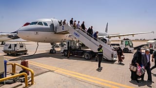 ركاب ينزلون من طائرة إيرانية في مطار النجف بعد انتهاء تعليق الرحلات الجوية الذي نجم عن الحرب الإقليمية التي اندلعت عقب ضربات أمريكية وإسرائيلية استهدفت إيران، وذلك في مدينة ال