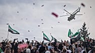 مروحية عسكرية تنثر الزهور وقصاصات الورق فوق حشود بإدلب احتفالاً بالذكرى الـ10 لانتصار المعارضة على قوات الأسد، 28 مارس 2025.