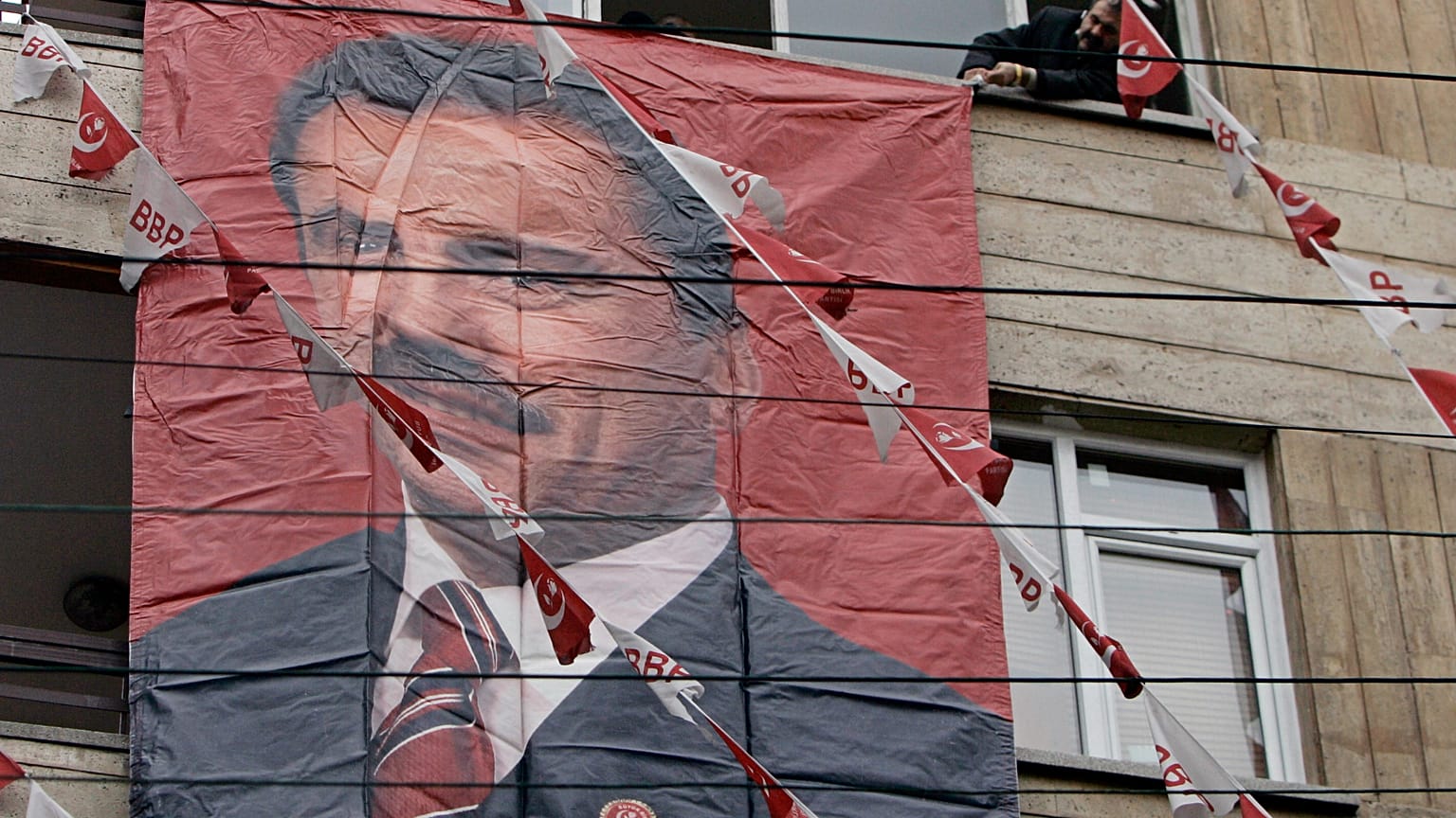 ARŞİV: Büyük Birlik Partisi (BBP) destekçesi, dönemin BBP genel başkanı Muhsin Yazıcıoğlu’nun posterini Ankara’daki parti genel merkezinin dışına asıyor; 27 Mart 2009, Cuma.