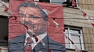 ARŞİV: Büyük Birlik Partisi (BBP) destekçesi, dönemin BBP genel başkanı Muhsin Yazıcıoğlu’nun posterini Ankara’daki parti genel merkezinin dışına asıyor; 27 Mart 2009, Cuma.