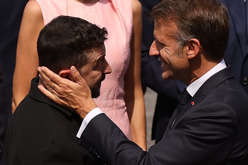 Emmanuel Macron francia elnök (jobbra) Volodimir Zelenszkij ukrán elnökkel beszélget a Bastille-napi katonai díszszemle után a párizsi Champs-Élysées sugárúton, 2026. július 14-én