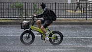 A cyclist rides during a sudden heavy rain in Tokyo, Thursday, Aug. 13, 2026.