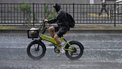 A cyclist rides during a sudden heavy rain in Tokyo, Thursday, Aug. 13, 2026.