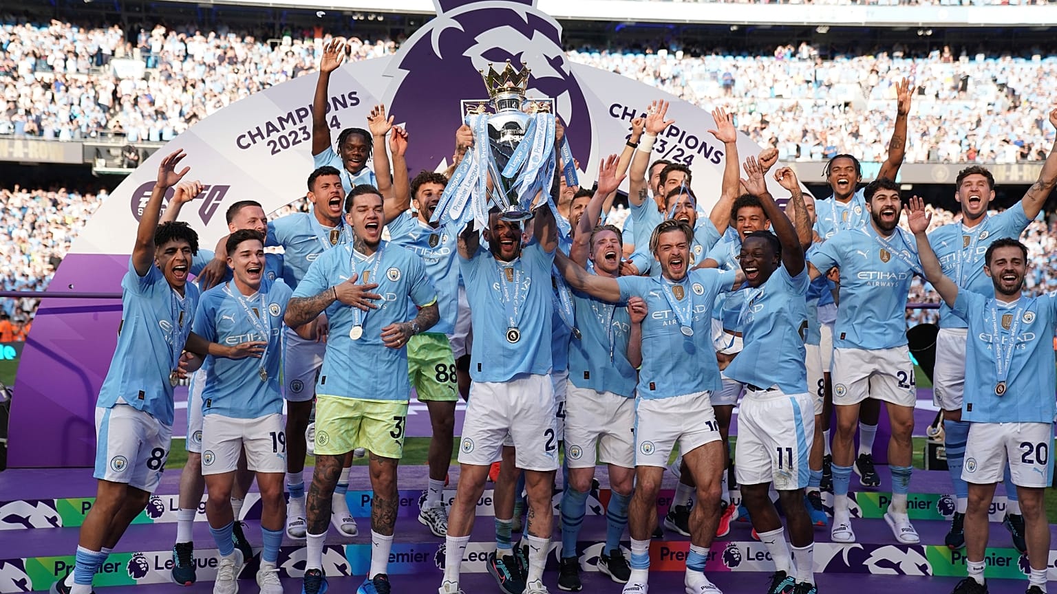 Manchester City players celebrate with the Premier League trophy after the English Premier League soccer match between Manchester City and West Ham United in Manchester.