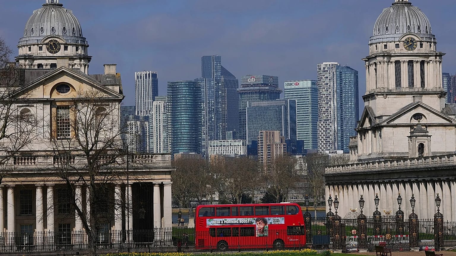 Photo d'archives — l'Old Royal Naval College à Greenwich encadre les immeubles du quartier financier de Canary Wharf, à Londres, jeudi 27 mars 2025.