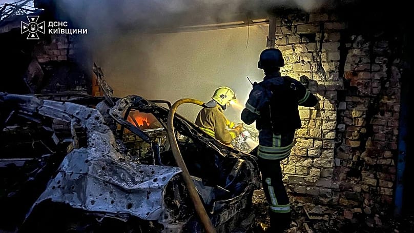 Rescuers put out a fire affecting garages destroyed after a Russian drone strike on Kyiv region, 30 September, 2026