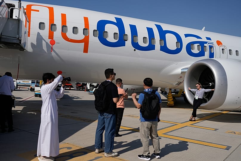 زوار يلتقطون صوراً بجانب طائرة "بوينغ 737 ماكس 8" تابعة لـ"فلاي دبي" خلال معرض دبي للطيران، 19 نوفمبر 2025.