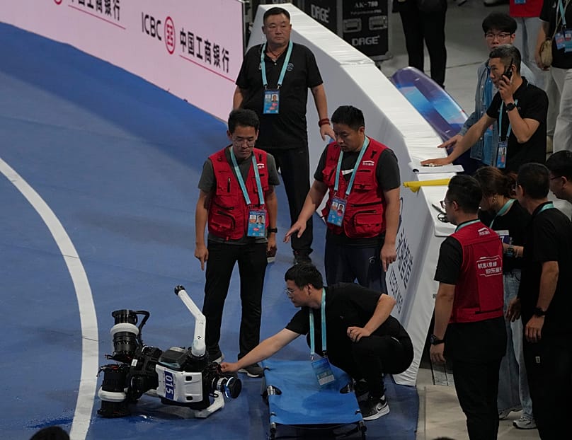 ARCHIVO. Un técnico revisa un robot tras una caída al final de la carrera de 1.500 metros durante los Juegos Mundiales de Robots Humanoides en Pekín, China, 23 de agosto de 2026