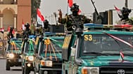 عناصر أمن عراقيون يرفعون علامة النصر أثناء استقلالهم مركبات ضمن موكب احتفالي بانسحاب القوات الأمريكية الكامل من العراق، في بغداد، يوم الأربعاء، 30 سبتمبر 2026.