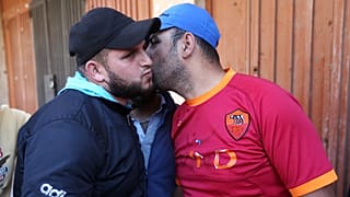 عناق بين أبو يوسف (علوي) وأبو هيثم (سني) إثر انتشار الجيش اللبناني بين جبل محسن وباب التبانة بطرابلس في 2 نيسان 2014 لإنهاء اشتباكات دامية.