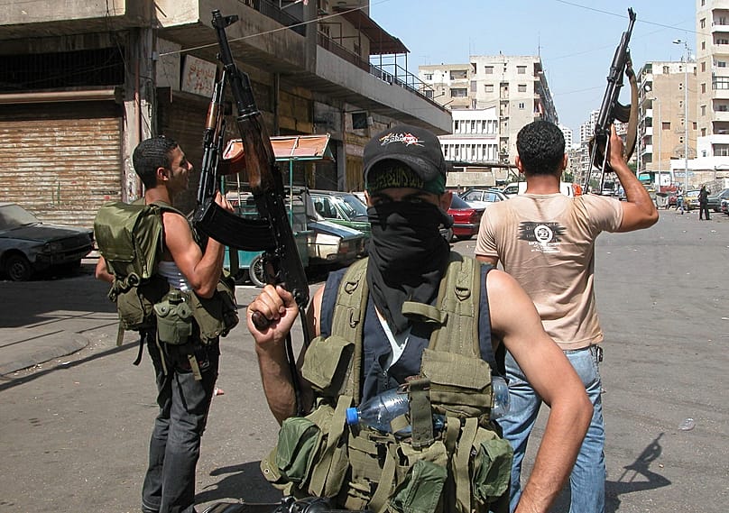مسلحون موالون لحكومة فؤاد السنيورة يشهرون أسلحتهم في باب التبانة بطرابلس شمال لبنان، 22 حزيران 2008، خلال اشتباكات مع معارضين في جبل محسن المجاور