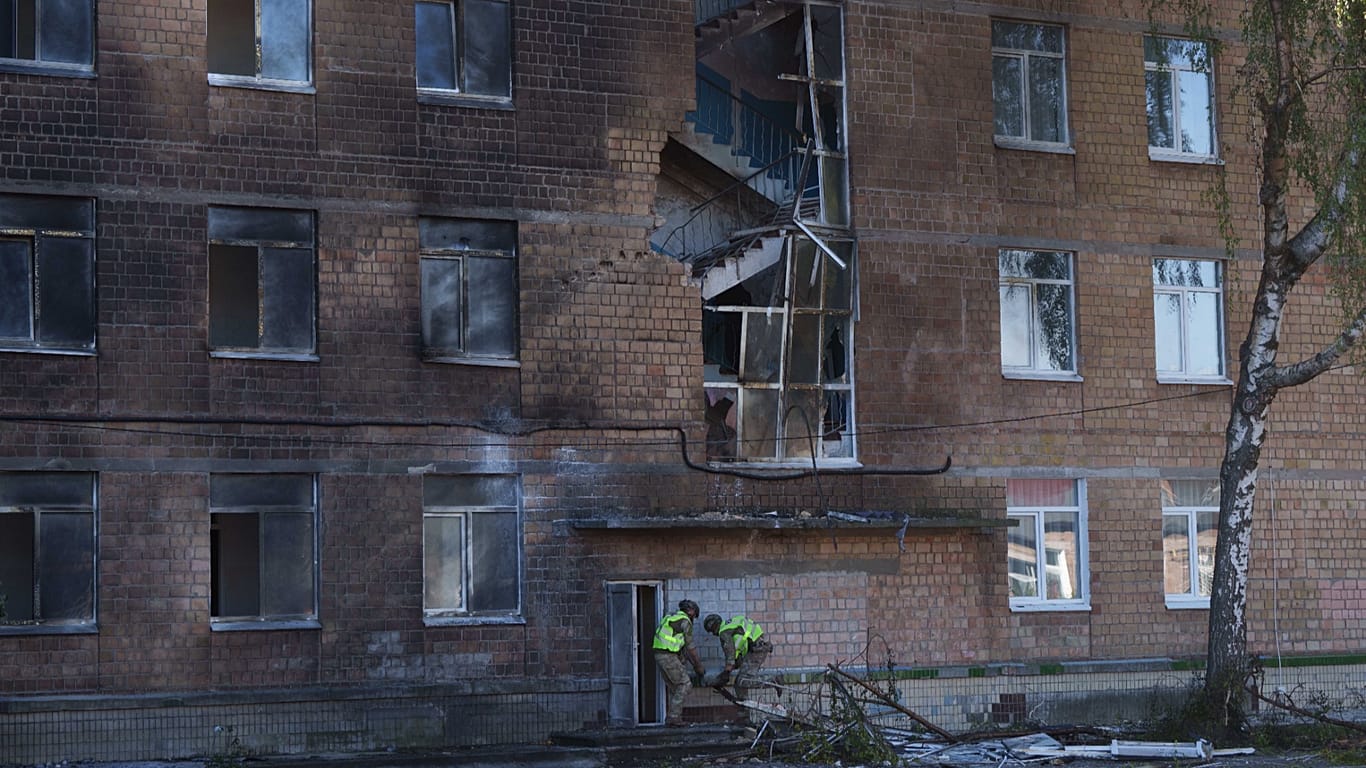 Police officers carry an unexploded warhead from a Shahed drone out of a school damaged by a Russian strike on Kyiv, 1 October, 2026